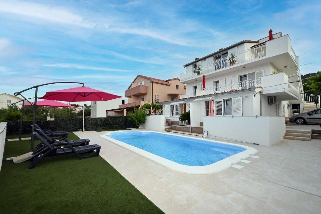 a swimming pool in front of a building at Apartment Mihovilovic in Slatine