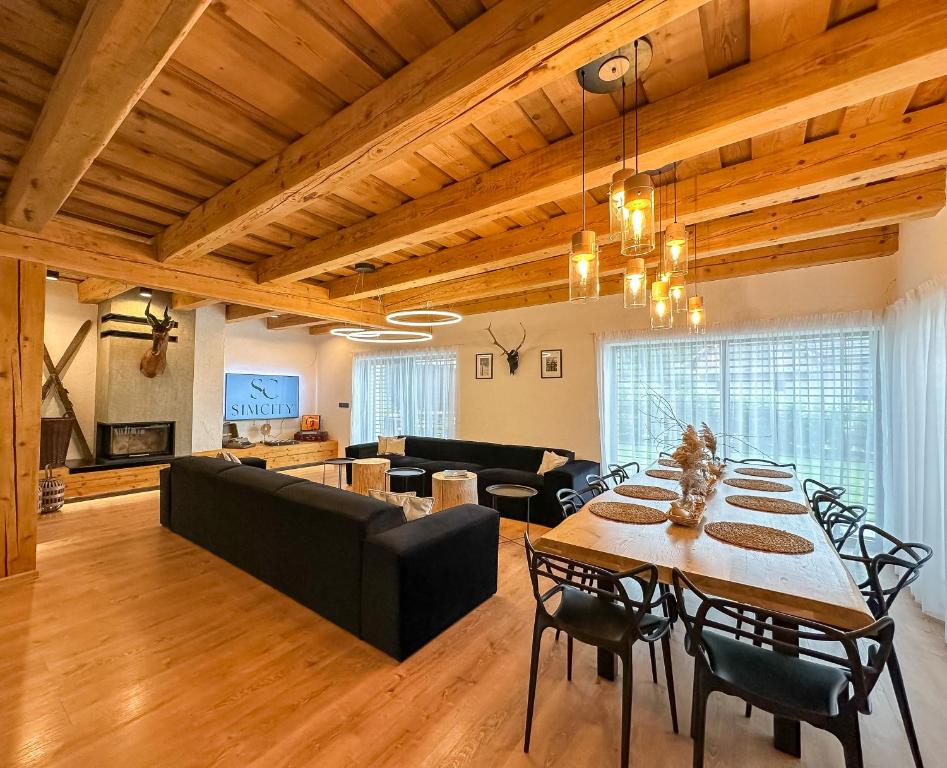 una sala de estar con una mesa y un sofá en Chalet Black Deer, en Mýto pod Ďumbierom