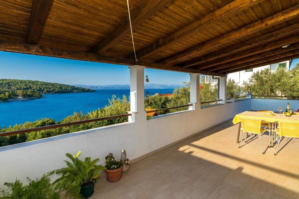 Un balcón con una mesa y vista al agua. en Apartment Mirja, en Nečujam