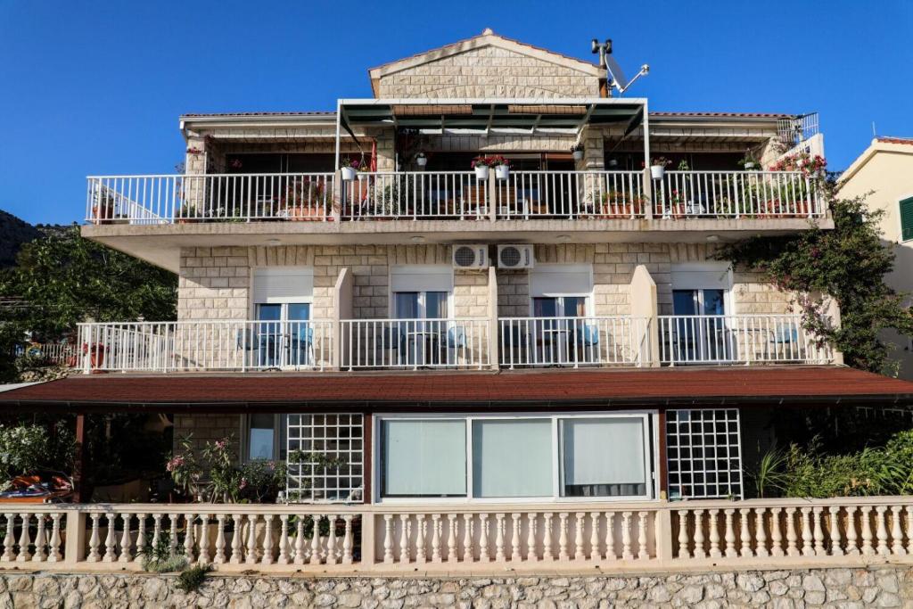 an old building with a balcony on top of it at Apartment and Rooms Marlene in Milna