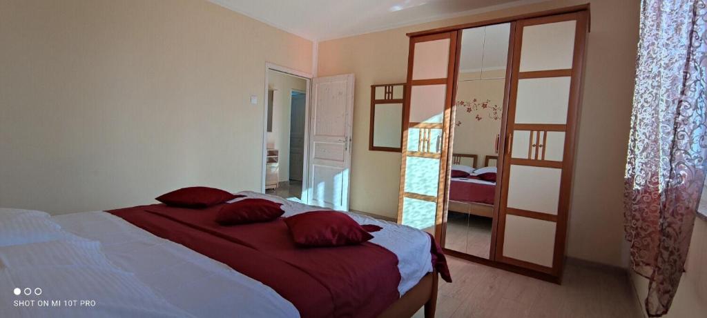 sypialnia z łóżkiem z czerwonymi poduszkami w obiekcie Apartment Nadica w Fažanie