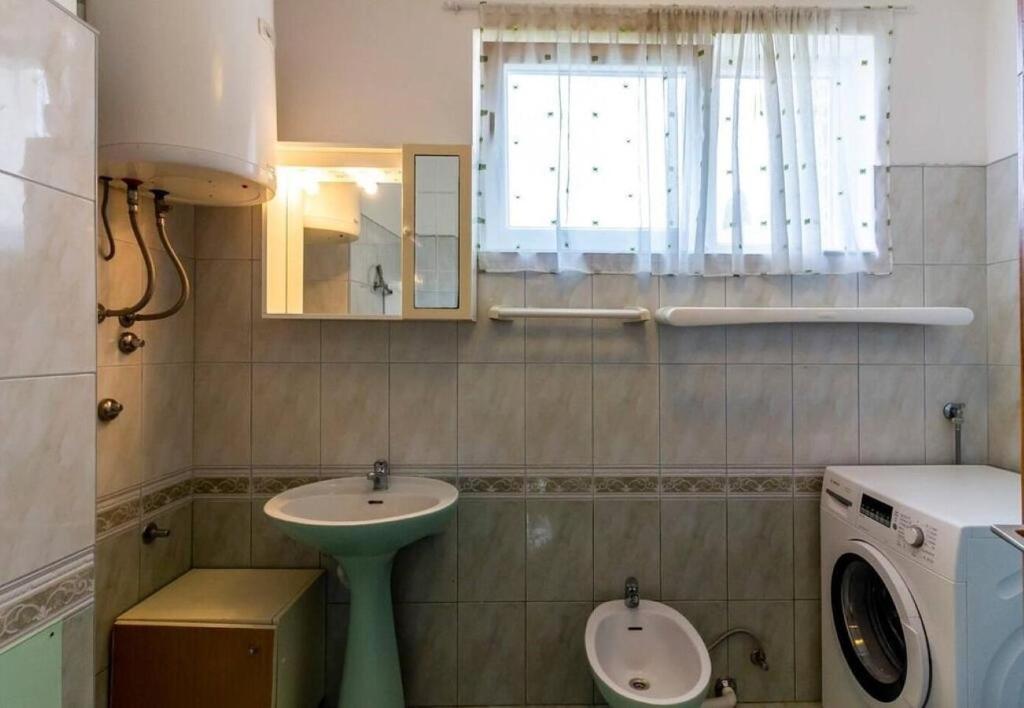łazienka z umywalką i pralką w obiekcie Apartment Nadica w Fažanie