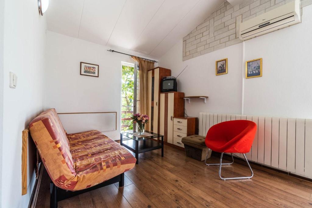 a living room with a couch and a red chair at Apartments Perci in Krnica