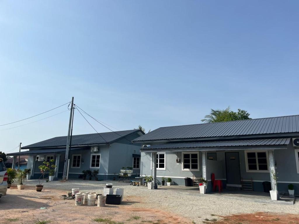 a group of houses with a car parked in front at Kencana L&K Homestay in Air Molek