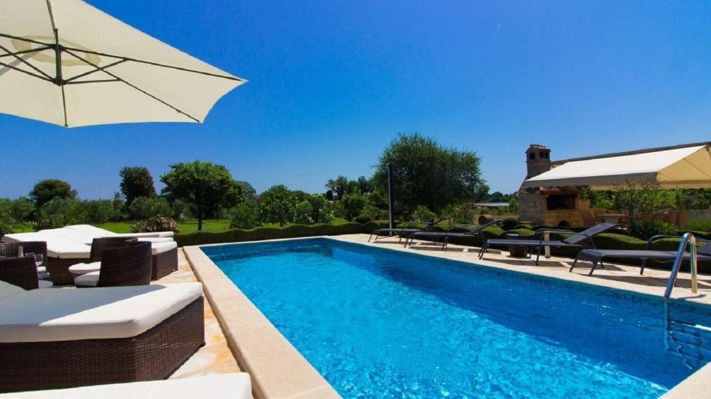 une piscine avec des chaises et un parasol à côté dans l'établissement House Kova, à Ližnjan
