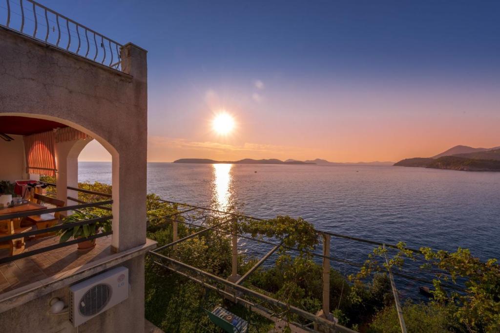 a sunset over the water from a building at Apartments Diana in Dubrovnik