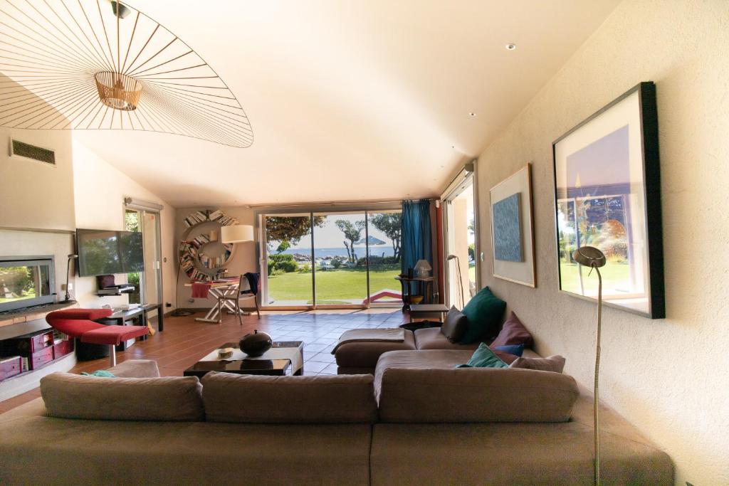 un salon avec un grand canapé et une télévision dans l'établissement A cala d oro et sa plage privée, à Porto-Vecchio