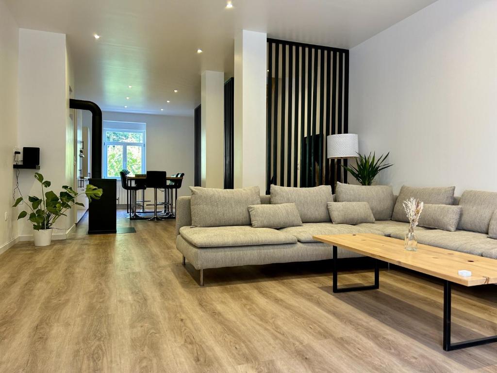 una sala de estar con un sofá y una mesa en Charmant quadruplex au cœur de la Vallée, en La Broque