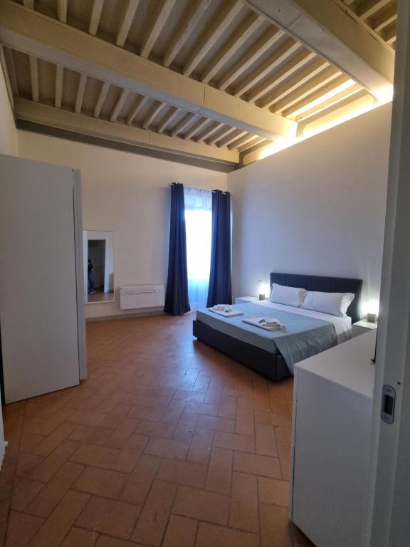a bedroom with a large bed and a window at 35 Rooms Palazzo Buoninsegni in Colle Val D'Elsa