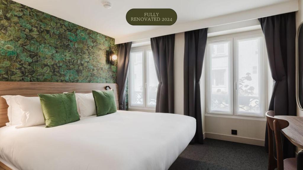 ein Schlafzimmer mit einem großen weißen Bett und grünen Kissen in der Unterkunft Hotel Prince Albert Opéra in Paris