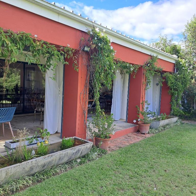 a red house with plants on the side of it at Corgi Cottage in Stanford