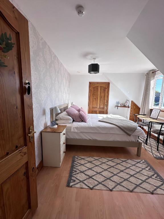 a bedroom with a bed with pink pillows on it at Malahide Guest Rooms in Malahide