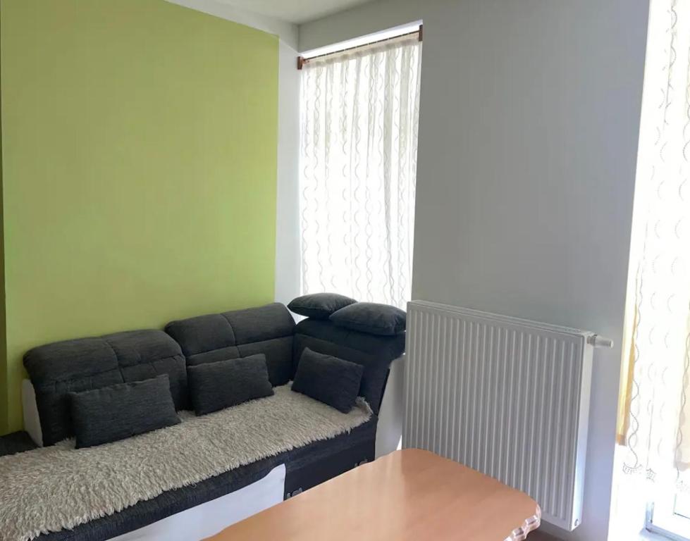 ein Wohnzimmer mit einem blauen Sofa vor einem Fenster in der Unterkunft Apartment Wien in Wien