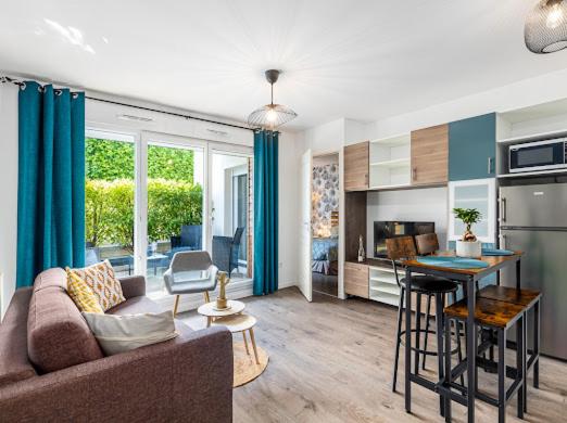 un salon avec un canapé et une table et une cuisine dans l'établissement Chez Julia et Kevin, à Serris