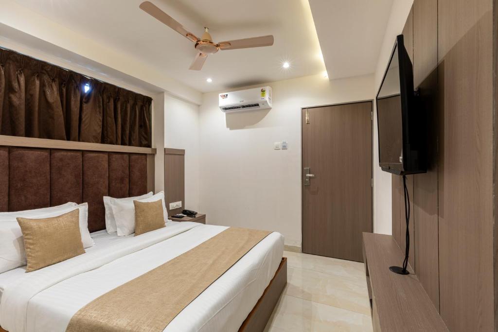 a bedroom with a bed and a flat screen tv at Hotel MetroMax Andheri in Mumbai