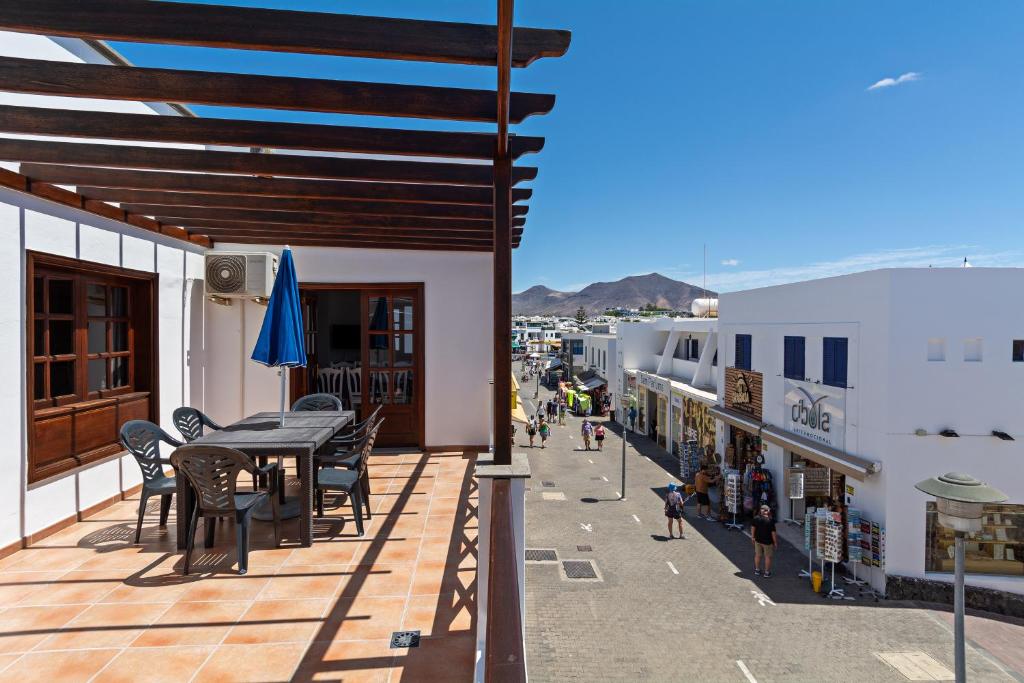 taras ze stołem i krzesłami na budynku w obiekcie Apartment Limonade Deluxe Main Center Playa Blanca By PVL w mieście Playa Blanca