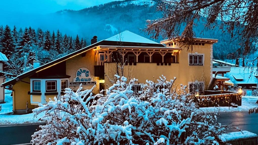 a building with snow covered bushes in front of it at Appartement Christina in Bad Kleinkirchheim