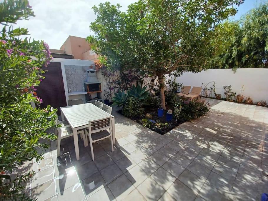 a patio with a table and a tree at Villa KITE KATE, cozy space, house and garden in La Oliva