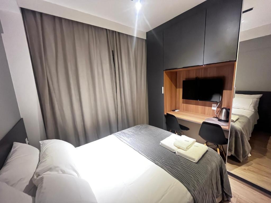 Hotel O Melhor Studio Do Brooklin, a hotel room with a bed and a desk with a computer at O Melhor Studio Do Brooklin in São Paulo