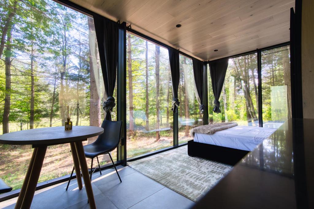 a room with a bed and a table and a window at The Haüs Windham - Spacious Suites, Hot Tub, Mountain Views! in Windham
