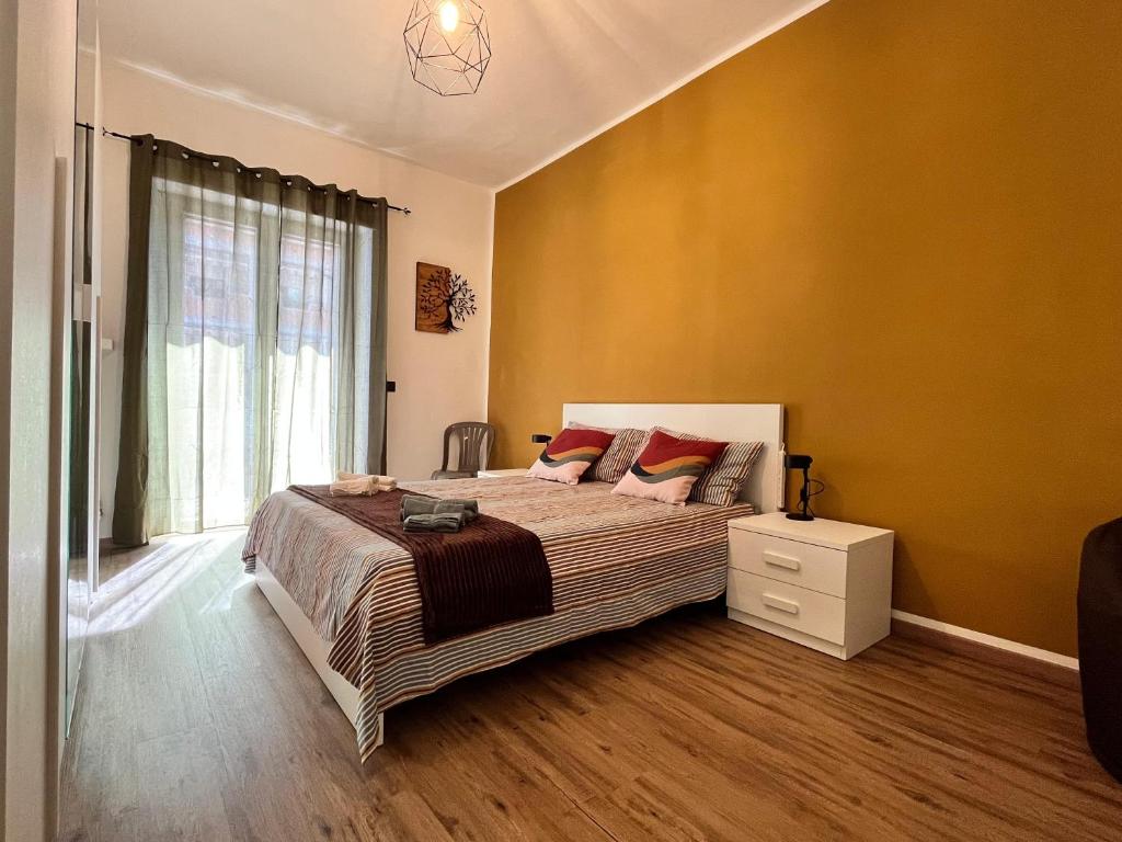 トリノにあるMinù House - Confortevole vicino al Centroの黄色の壁のベッドルーム1室