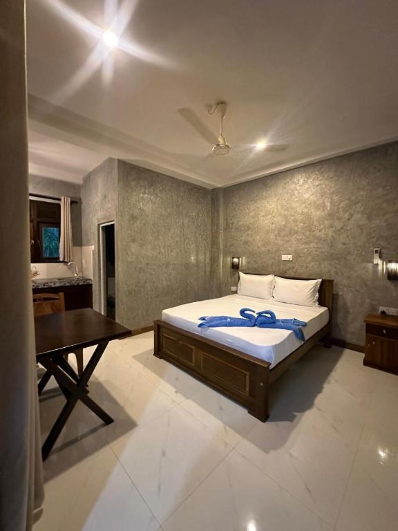a bedroom with a bed and a table in it at Villa Secret Stream in Mirissa