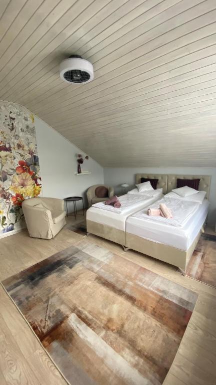two beds in a room with a ceiling at Sweet Home Apartman in Balatonfüred