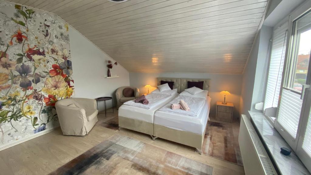 a bedroom with a bed and a chair in a room at Sweet Home Apartman in Balatonfüred