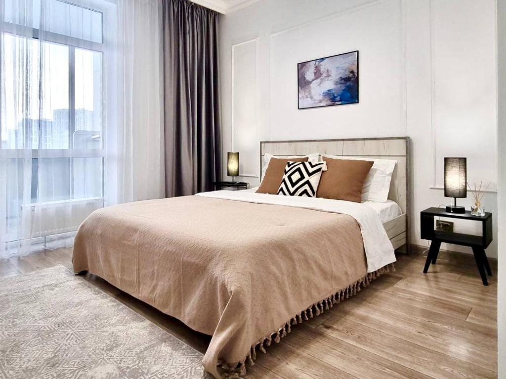 a bedroom with a large bed and a window at Tokyo, a Residential Complex in Astana