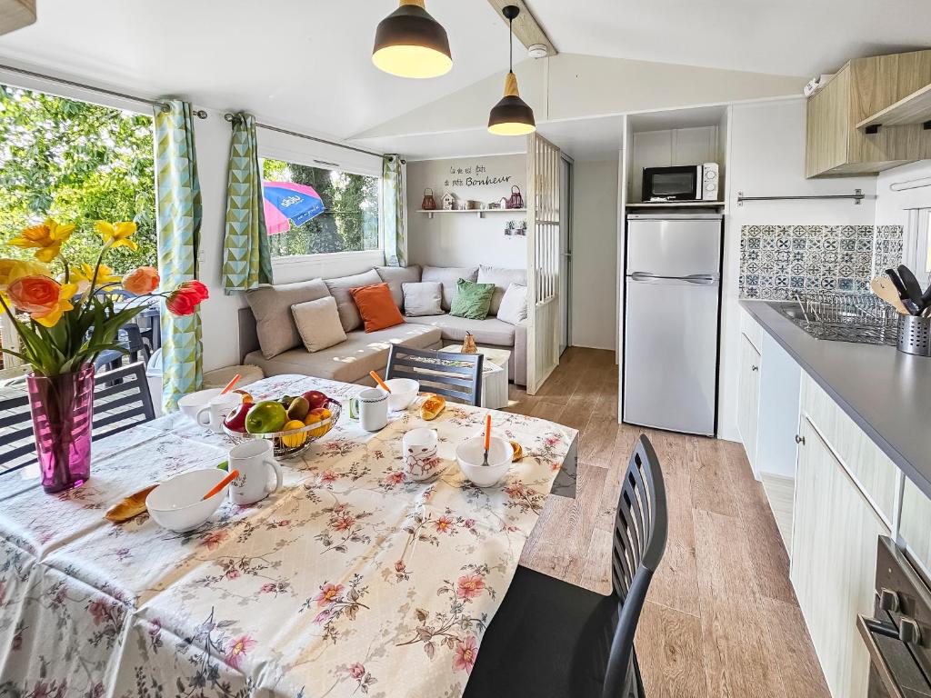 a kitchen and living room with a table with fruit on it at Mobile Home Eden in Litteau