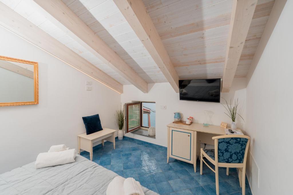 a room with a bed and a desk and a tv at Albergo Diffuso Bacco Furore in Furore