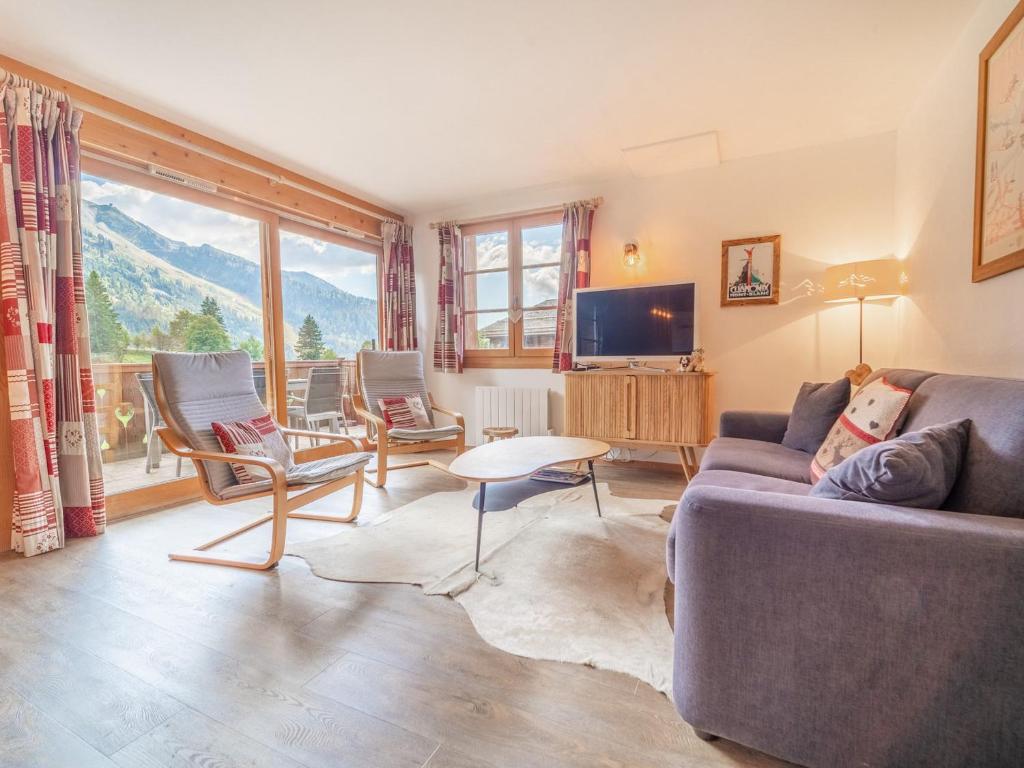 un salon avec un canapé, des chaises et une télévision dans l'établissement Bel Appart 6 Pers - 2 Ch - Terrasse Sud - Garage - WIFI - La Clusaz - FR-1-437-105, à La Clusaz