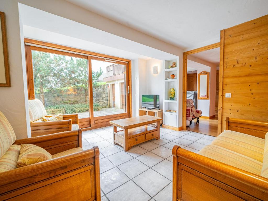 a bedroom with two beds and a living room at Appartement 3 chambres avec terrasse, centre village, piste et commerces à pied, garage et WIFI - FR-1-437-104 in La Clusaz