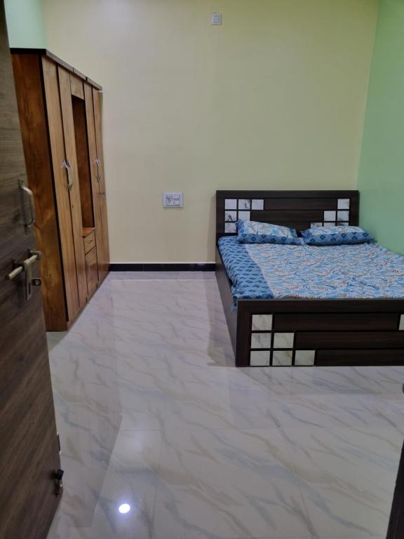 two beds in a room with a door and a floor at Relax stay in Belgaum