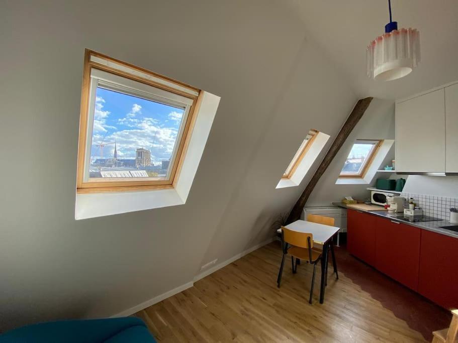 une cuisine avec une fenêtre, une table et un comptoir dans l'établissement Studio Victoria - Centre de Paris, à Paris