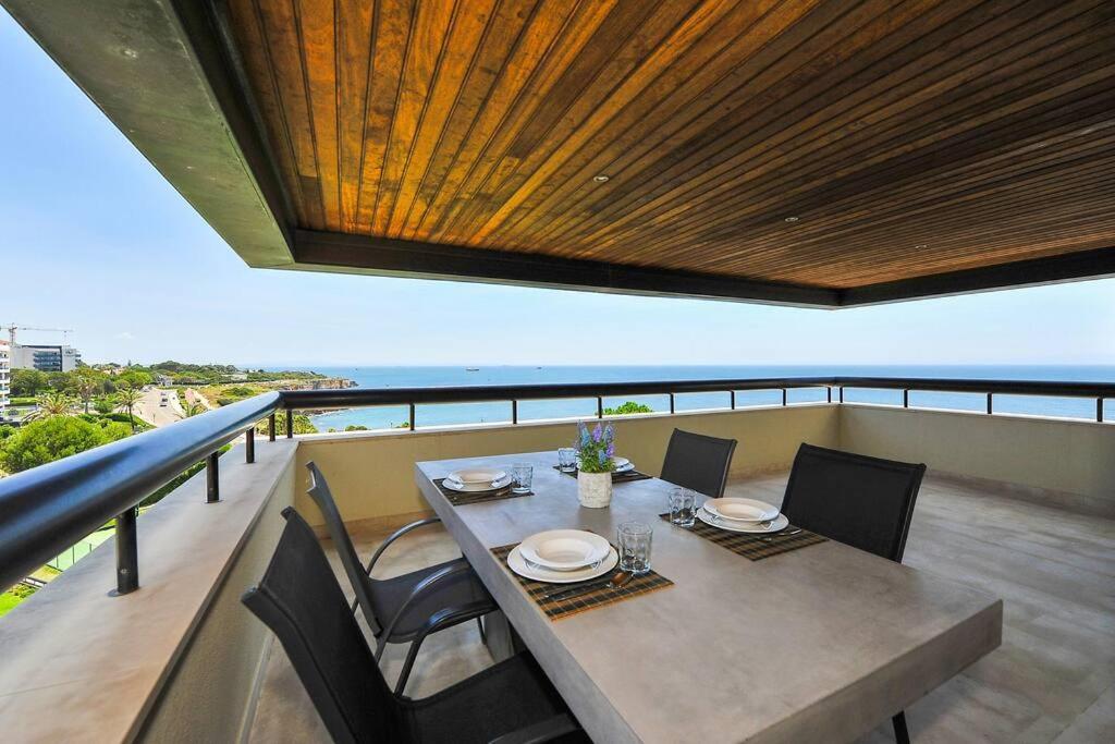 a dining table and chairs on a balcony with the ocean at Amazing Sea View in Cascais