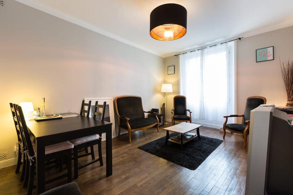 un salon avec une table et des chaises de salle à manger dans l'établissement Flamboyant Lutèce - Élégance Parisienne au Cœur de la Ville, à Paris