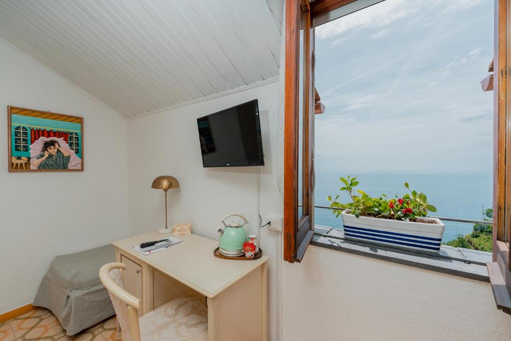 a room with a desk and a window with a table at Albergo Diffuso Bacco Furore in Furore