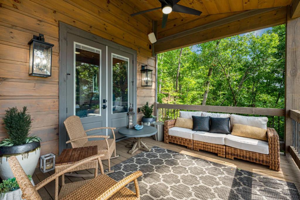 eine abgeschirmte Veranda mit einem Sofa und Stühlen darauf in der Unterkunft Elevated Escape - Luxurious Mountain Views - Hot Tub, Game Room, Fire Pit, Full Mountain Views - Escape to Luxury North Georgia in Cherry Log
