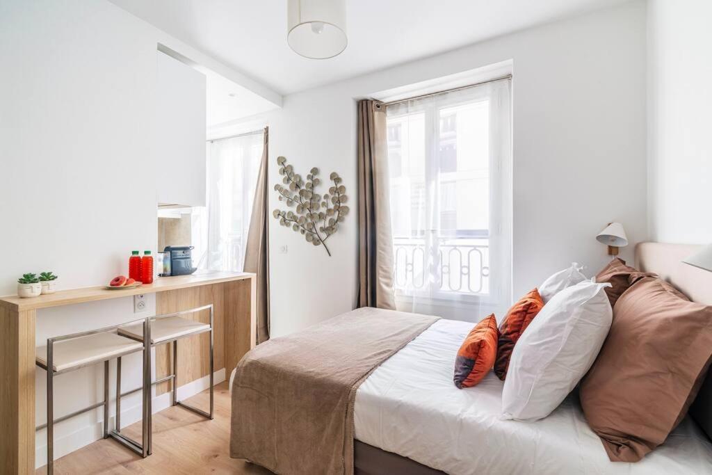 une chambre avec un lit, un bureau et une fenêtre dans l'établissement Studio au centre de Paris - Musée Grévin - II, à Paris