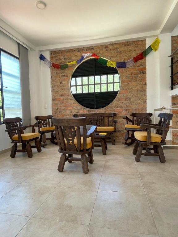 een kamer met houten tafels en stoelen en een raam bij Hospedaje El Caminante CAPI in Capitanejo