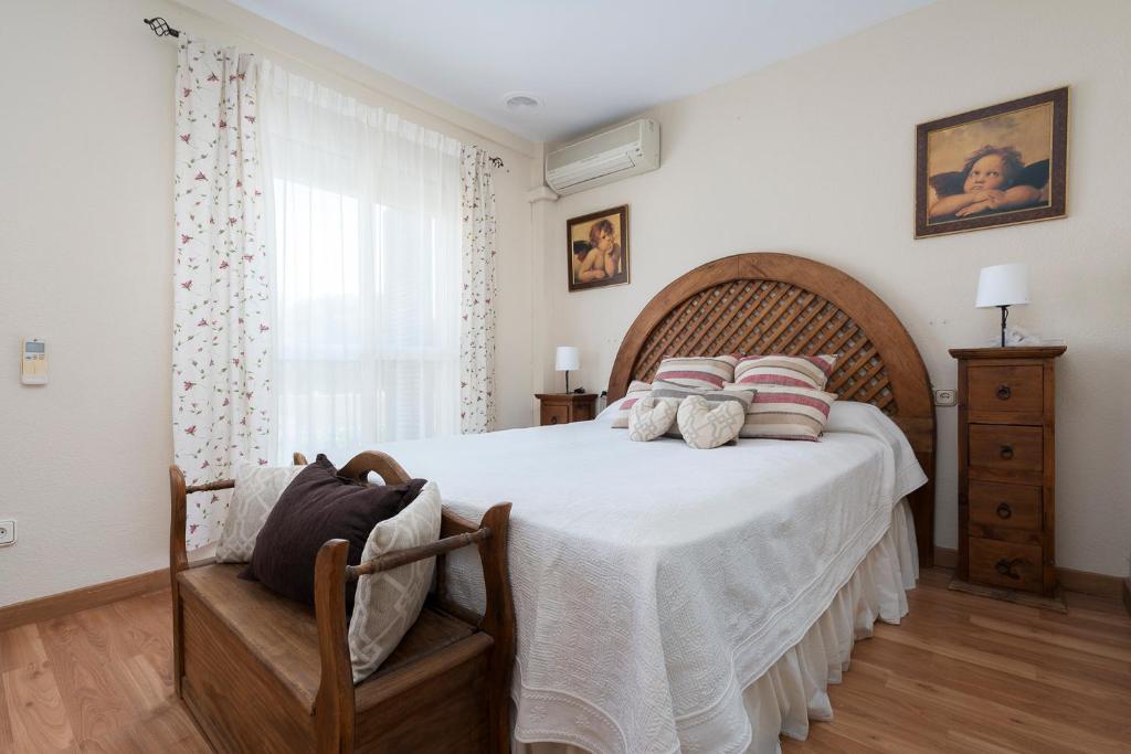 a bedroom with a large bed with a wooden headboard at Chalet Pareado & Piscina in El Puerto de Santa María