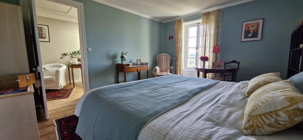 een slaapkamer met een groot bed met blauwe muren bij Chambres d'Hôtes Les Jardins de la Cathédrale in Angoulême