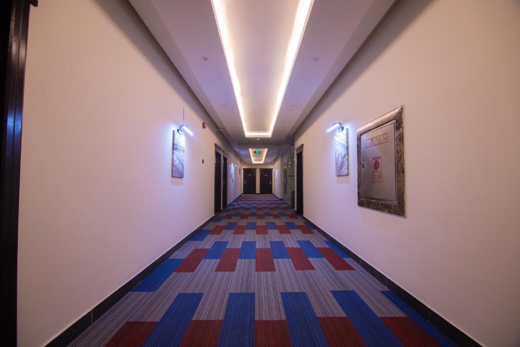 a hallway with a long corridor with colorful carpet at Towlan Alfalah تولان الفلاح للشقق المخدومة in Riyadh