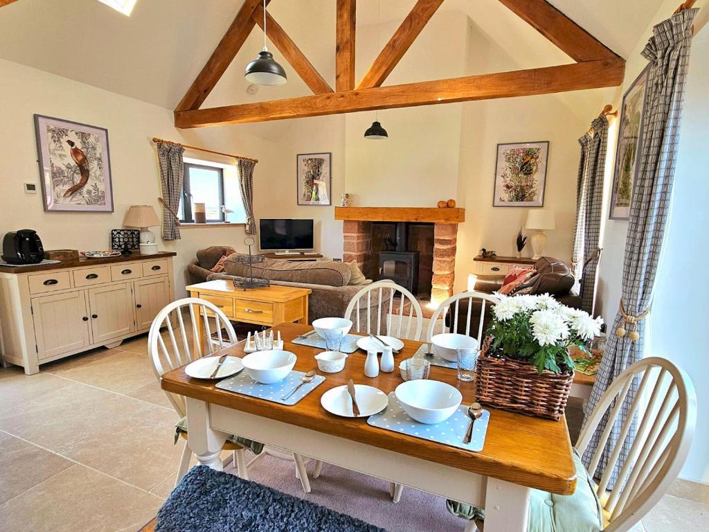a kitchen and living room with a wooden table and chairs at Beautiful Views Historic 16th Cent Barn Conversion - Pass the Keys in Bridgnorth
