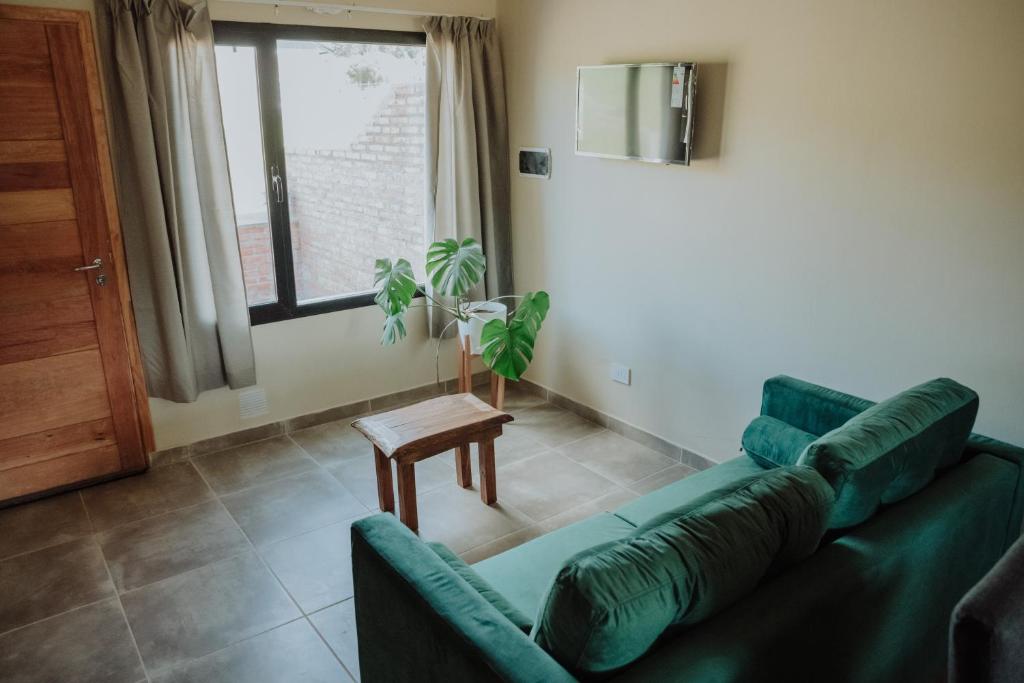 a living room with a green couch and a table at Las Loicas Tempo in Esquel