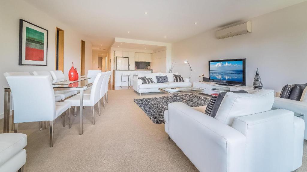 a living room with white furniture and a television at 9/4 The Esplanade, Cowes - Cscape in Cowes