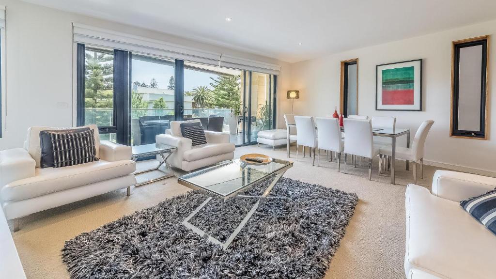 a living room with white furniture and a table at 9/4 The Esplanade, Cowes - Cscape in Cowes