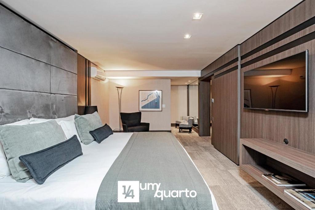 a hotel room with a large bed and a desk at Edifício Praça Osório in Curitiba