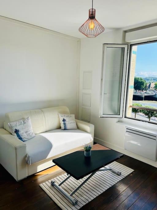 un salon avec un canapé et une fenêtre dans l'établissement Le Cocon au bord de la mer, à Trouville-sur-Mer